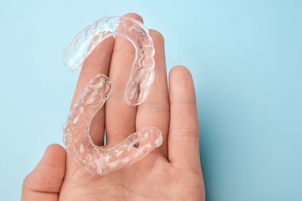 hand holding a pair of invisalign